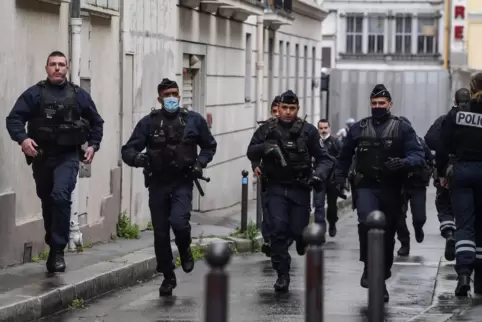 Französische polizisten eilen zum Tatort. 