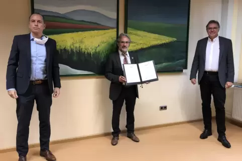 Bildungsstaatssekretär Hans Beckmann (rechts) überreicht mit ISB-Vorstandsmitglied Ulrich Link (links) den Förderbescheid an den