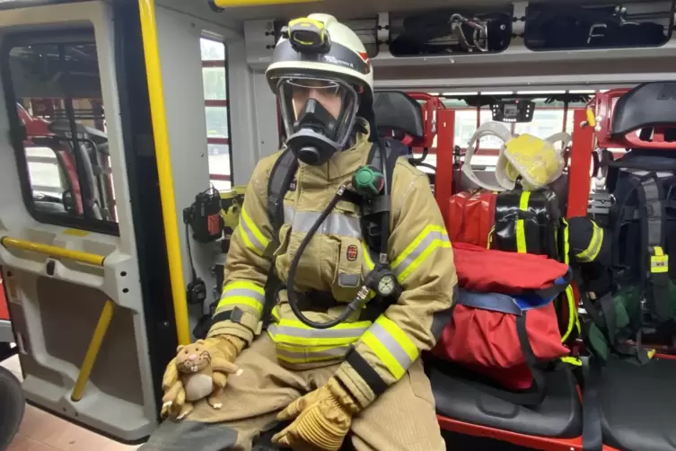 FSJ-ler Max Pfundstein zeigt Nils, wie er in voller Montur im Feuerwehrauto sitzt.