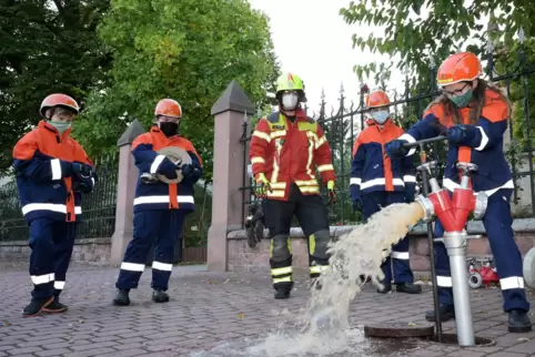 Dreht den Hydranten am Königsplatz auf: Jugendfeuerwehr-Mitglied Anna Hoffmann. Ihr schauen Frederic Hollstein, Laura Burkhardt,