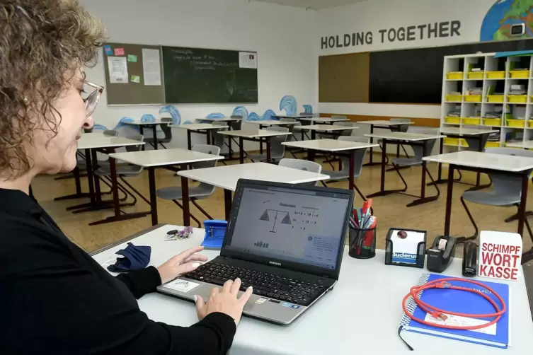 Lehrerin Sophia Hermann unterrichtet in einer leeren Klasse, die Schüler sind online dabei.