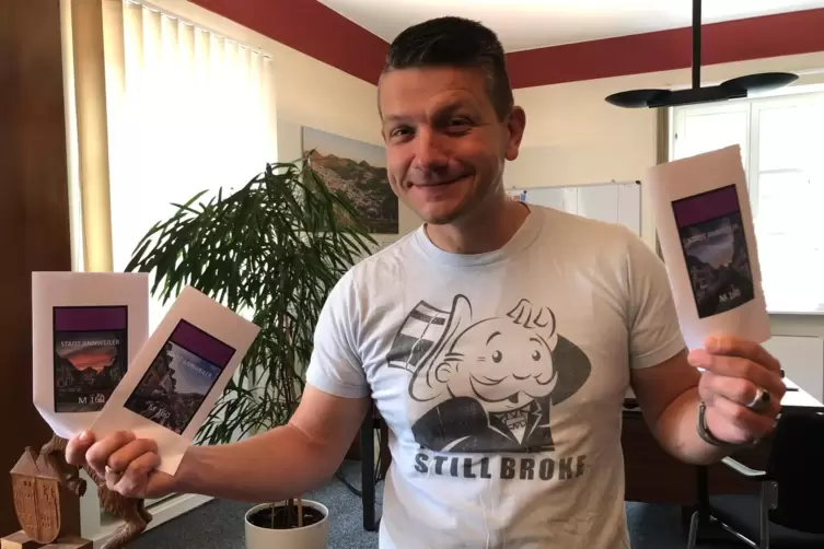 Annweilers Stadtb&uuml;rgermeister Benjamin Seyfried mit den drei Motiven, die f&uuml;r das Annweiler-Feld zur Wahl stehen.