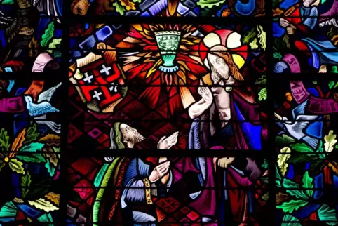 Von leuchtenden, rot-gelben Flammen ist der Gral in diesem Fenster umringt, das sich in der Kirche Eglise du Graal in Trehorente