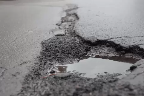 Regenwasser in Schlaglöchern: Die Dorfstraße in Hertlingshausen muss dringend saniert werden. 