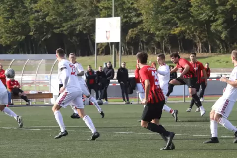 Michael Meyer (rot, rechts) schießt in Bellheim das 1:0 für Neuburg. 