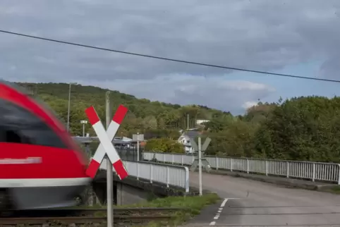 Andreaskreuz und weitere Schilder weisen auf den Bahnübergang hin.