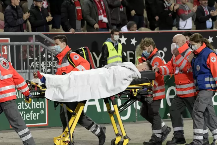 Auf dem Weg ins Krankenhaus: Sanit&auml;ter bringen den am linken Unterschenkel verletzten Dominik Schad aus dem Stadion.