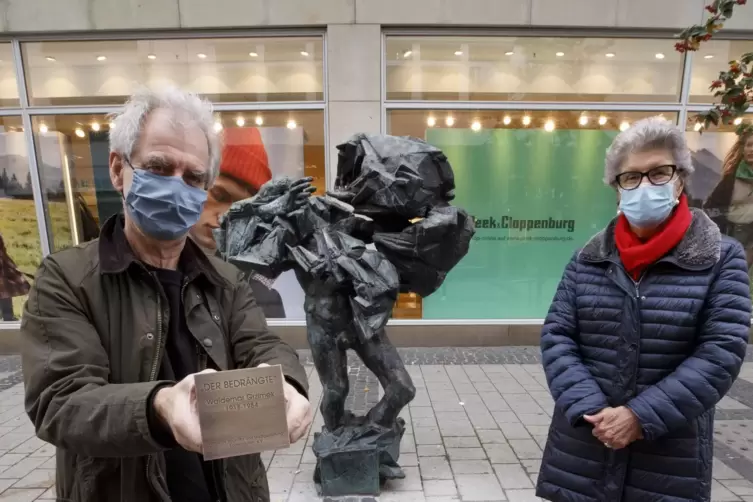 Martin Heyl hält die Messingplakette in der Hand, die die Skulptur als den „Bedrängten“ ausweist; rechts die Vorsitzende des Ver