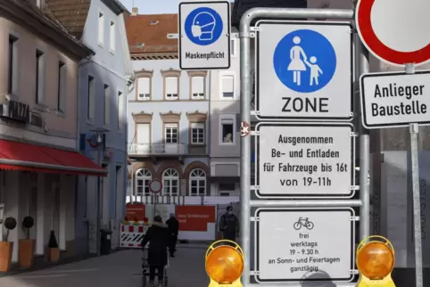 Ein Schild weist in der Kaiserslauterner Innenstadt auf die Maskenpflicht hin.