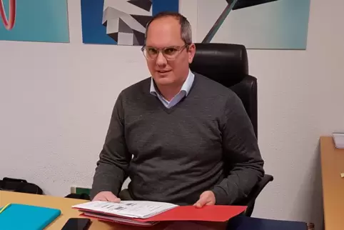 Akten vor der Brust, Stadtmotive im Rücken: Lukom-Chef Christoph Keimes am Schreibtisch seines Büros in der Walzmühle.