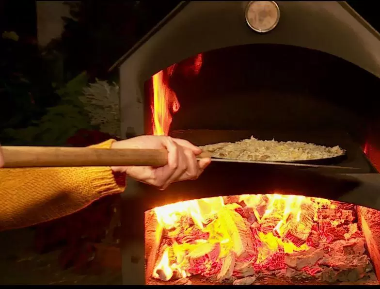 Die Pizza in den Ofen schieben – bei einem Elektroherd 220 Grad Umluft.