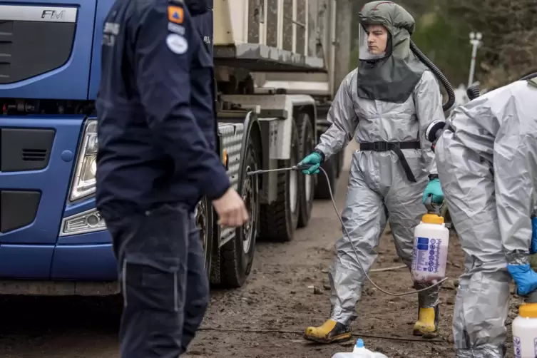 Mitarbeiter der dänischen Gesundheitsbehörde reinigen mit Hilfe dänischer Militärs die Fahrzeuge welche für die Entsorgung von N