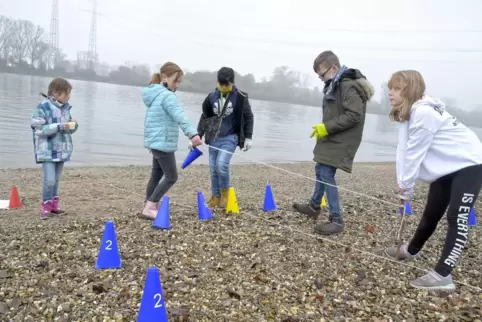 Lilly, Lotta, Yaseen, Niklas und Latoja stecken an der Mündung des Eckbachs in den Rhein einen Stichprobenkreis ab.