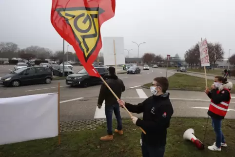 Mit Fahnen und Schildern macht die IG Metall auf ihre Forderungen aufmerksam.
