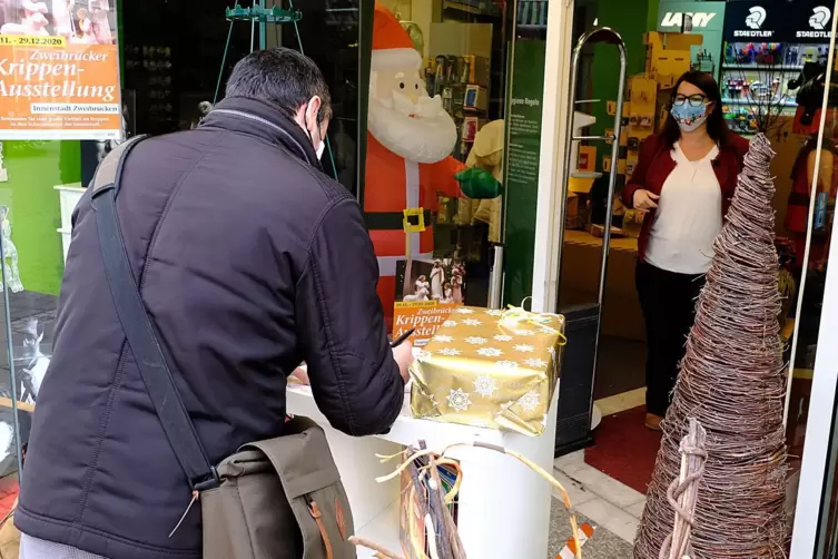Ein Kunde holt bei Sandra Cleemann ein bestelltes Spielzeug ab. 