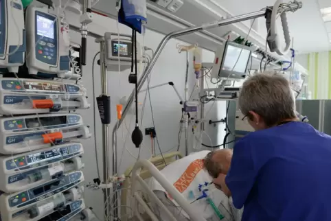 Eine Krankenschwester betreut in einem Krankenhaus auf der Intensivstation einen Patienten. 