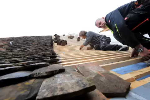 Dachdecker decken das Dach mit alten Ziegeln.