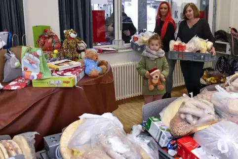 Polly-Minou und Melanie Heck (von links) bringen Geschenke zur Tafel-Ausgabestelle im Kurpfalztreff. Heidelore Bigott (rechts) f