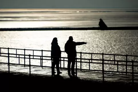Beliebtes Urlaubsziel 2021? Die Nordsee, hier in Wilhelmshaven: Spaziergänger stehen auf einer Mole und blicken auf den Jadebuse