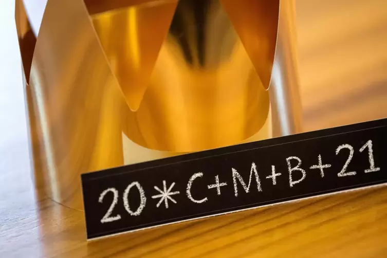 Ein Aufkleber mit der Aufschrift «20*C+M+B+21» liegt neben einer Krone. Die Buchstaben stehen für den Wunsch «Christus mansionem