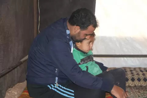 Mohammed mit einem seiner Kinder im kalten Zelt. Seit drei Jahren ist er mit seiner Familie auf der Flucht.