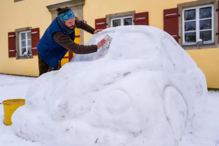 Stefan Parnt fegt frisch gefallenen Schnee von dem Schnee-&bdquo;K&auml;fer&ldquo;. 