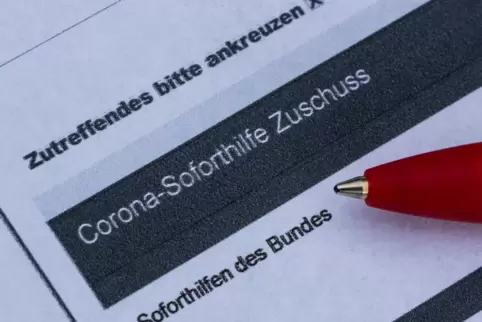 Ein Stift liegt auf einem Antrag für den Corona-Soforthilfe-Zuschuss. 