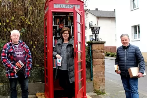 Volker und Annette Glade haben die Bücherbox in der Telefonzelle eingerichtet, Bürgermeister Timo Bäuerle bringt Nachschub. 