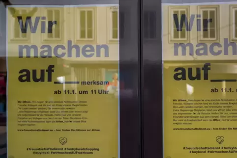 Hinweisschilder der Aktion "Wir machen aufmerksam" hängen am Eingang eines Bekleidungsgeschäfts in der Trierer Innenstadt.