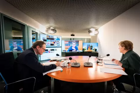 Kanzlerin Angela Merkel (rechts) und Berlins Regierender Bürgermeister Michael Müller in der Videoschalte mit den Ministerpräsid