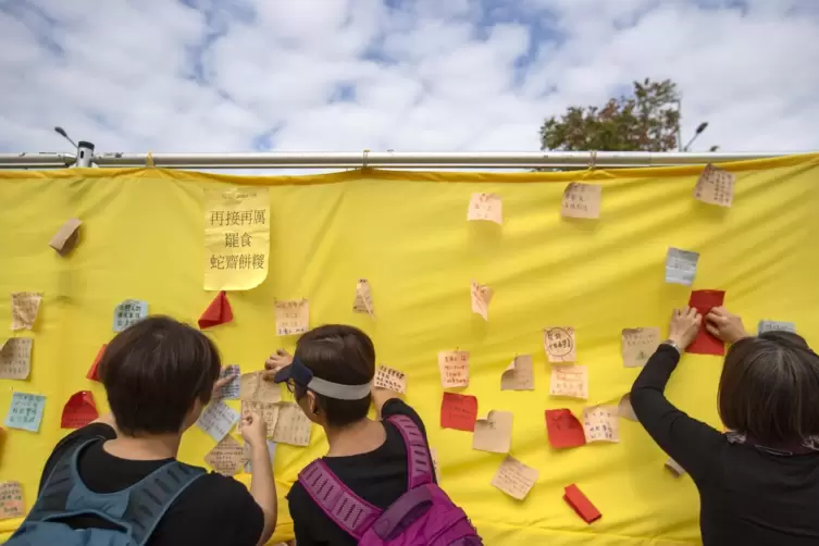 Gelb steht f&uuml;r die Demokratie: Demonstranten befestigen Botschaften auf einem Banner w&auml;hrend einer Kundgebung. 