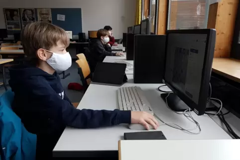 Julius Heß, Moritz Bösl und Till Bösl spielen Online-Schach gegen Schüler aus Moskau.