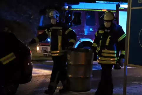Feuerwehrleute mit einem Fass mit Lösungsmittel. Feuerwehrleute mit einem Fass mit Lösungsmittel.