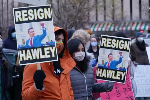 Demonstrantinnen forderten den Rücktritt von Senator Josh Hawley. Auf ihren Plakaten ist ein Bild zu sehen, das zeigt, wie Hawle