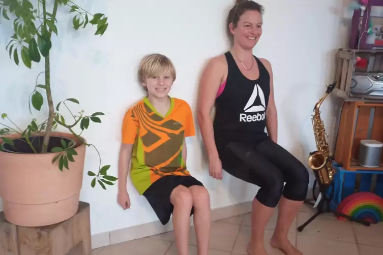 Bewegungsmanagerin Britta Blankenfuland und ihr Sohn Leo haben unter dem Motto „Klein gegen Groß“ eine Mini-Wandsitz-Challenge g