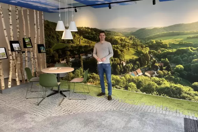 DTV-Geschäftsführer Simon Lauchner vor der mehrere quadratmetergroßen Fototapete von Falkenstein, die die neue Geschäftsstelle o