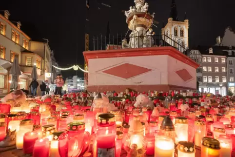 Eine Woche nach der Amokfahrt: Kerzen brennen rund um den Petrusbrunnen in der Trierer Fußgängerzone.