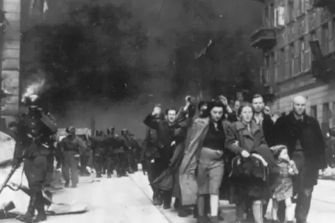 Auf diesem Bild von 1943 wird eine Gruppe polnischer Juden von deutschen SS-Soldaten zur Deportation abgeführt, während das Wars