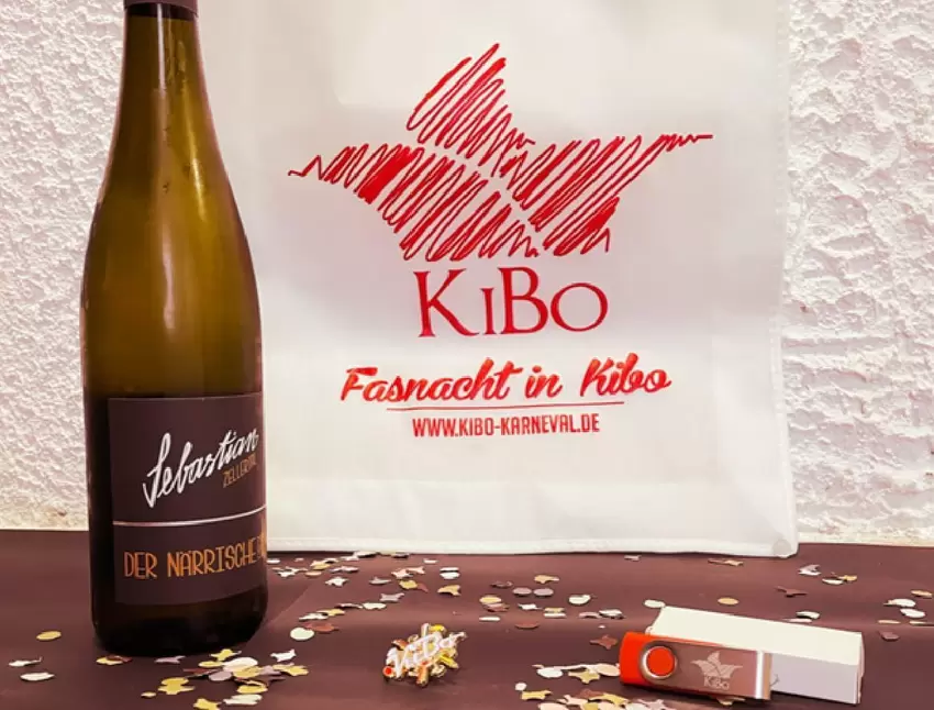 Wein, Konfetti, Ansteck-Pin und ein Stick mit früheren Auftritten: Die Kibo Karnevalgesellschaft hat einen "Sitzung-fer-dehääm-B