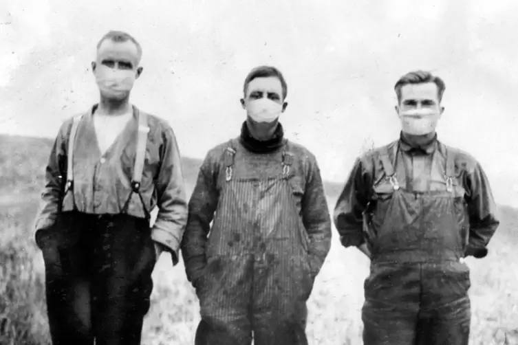 Drei Bauern aus derkanadischen Provinz Alberta versuchen sich 1918 mit durchlässigen Gazemasken vor der Spanischen Grippe zu sch