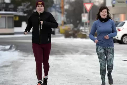 Martin Jeck und Kathy Ermert joggen im Schnee.