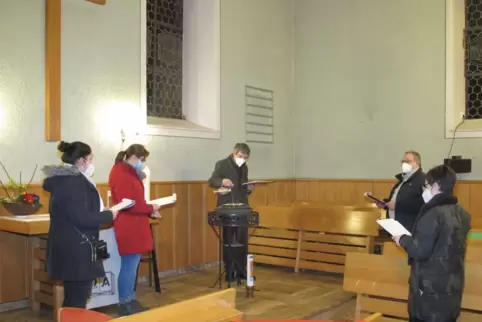 Die neuen Presbyter versammelten sich um den Taufstein, hinter dem Pfarrer Matthias Schröder steht. 
