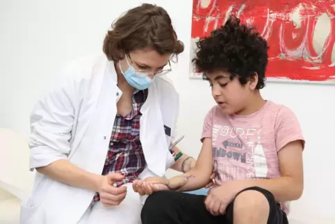 Die Leitende Oberärztin Leila Harhaus untersucht den neunjährigen Wahdatullah, der inzwischen seine Finger wieder bewegen kann.