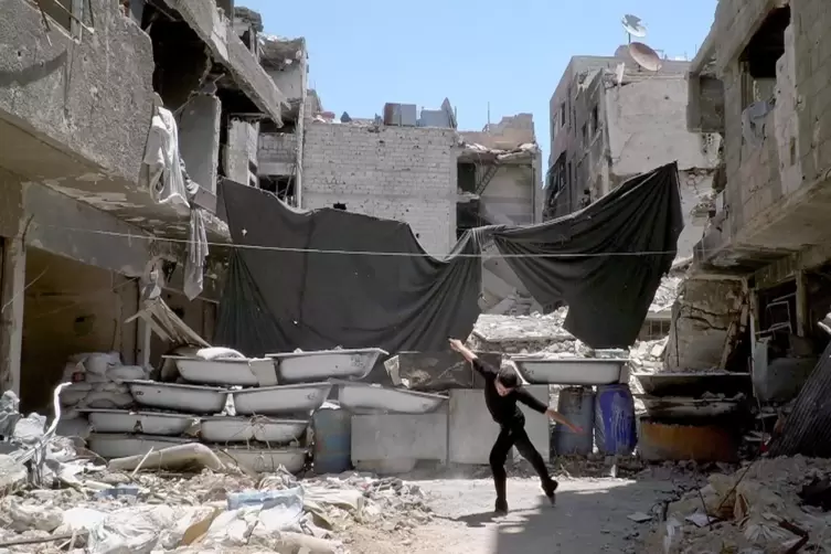 Unbeirrt von den Schüssen tanzt der Syrer Ahmad Joudeh im zerbombten Viertel in Damaskus, wo er früher gelebt hat. Die Dokumenta