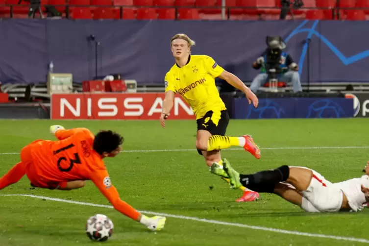 Erling Haaland (M) von Dortmund erzielt das Tor zum 1:3 gegen Torwart Yassine Bounou "Bono" (l) von Sevilla.