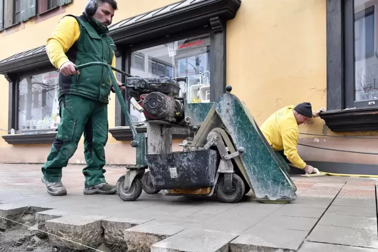 Delfim Almeida (links) und Joao Pereira k&uuml;mmern sich in der Laustergasse um die Fugen.