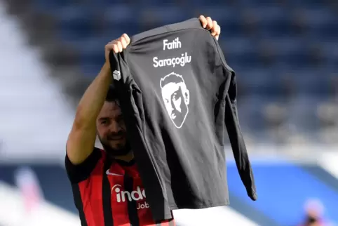 Frankfurts Amin Younes hält ein Trikot mit dem Porträt von Fastih Sarancoglu, einem der Opfer des Terroranschlags von Hanu vor e