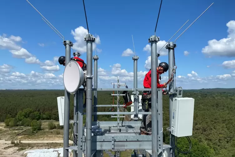 Arbeiter montieren Antennen für die fünfte Mobilfunk-Generation. 