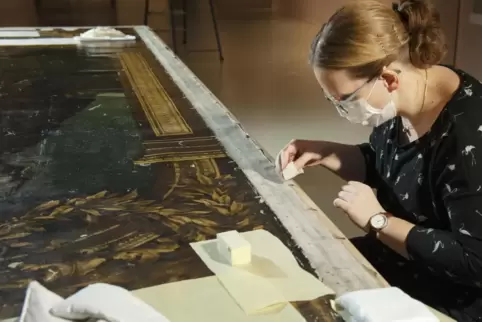 Katharina Deimel befreit die Leinwand von altem Schmutz. 