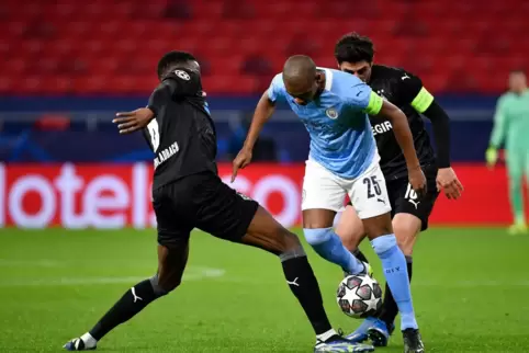 Gladbachs Denis Zakaria (links) und Gladbachs Lars Stindl kämpfen um den Ball gegen Manchester Citys Fernandinho
